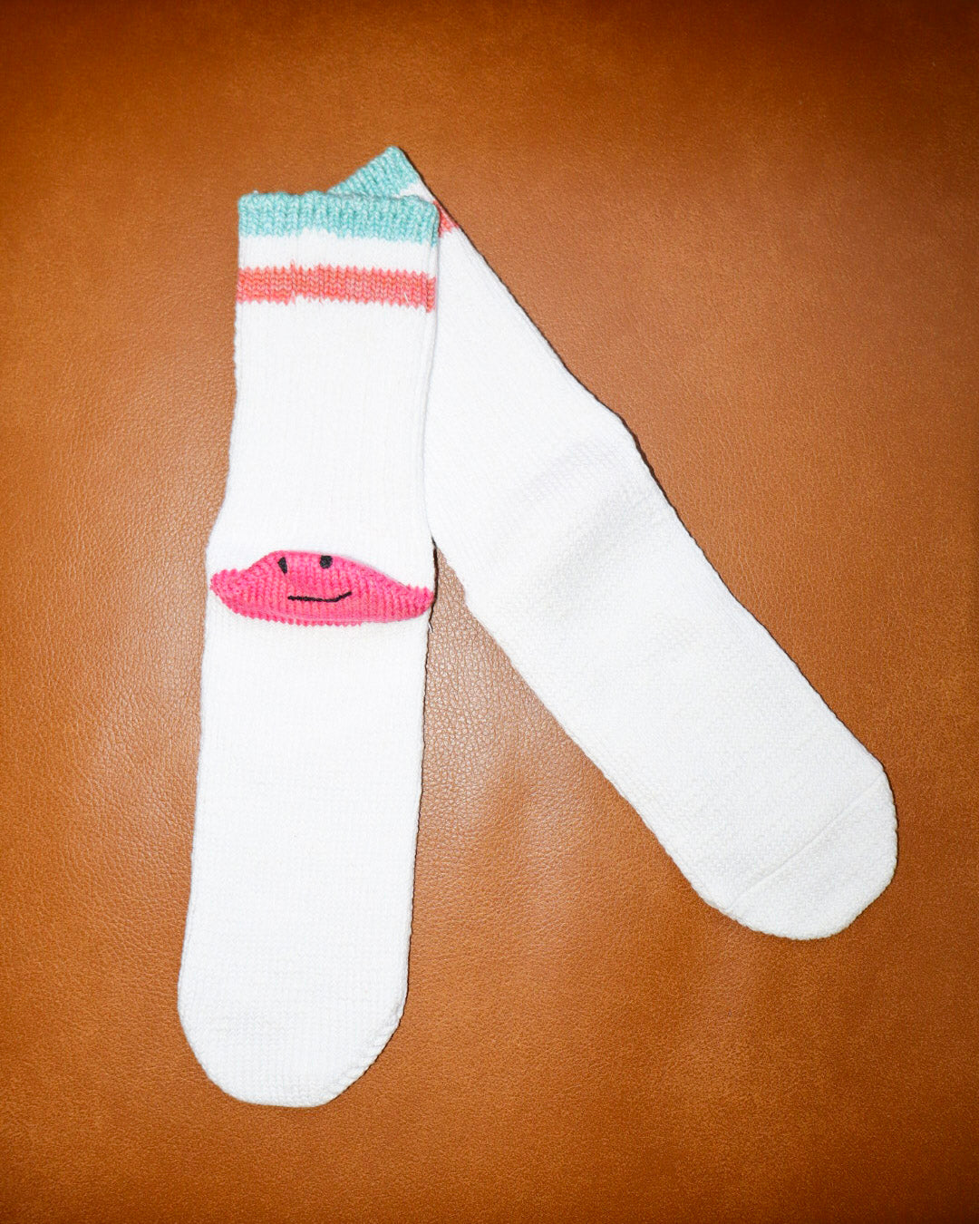 White sock with a smiley face design on a brown surface