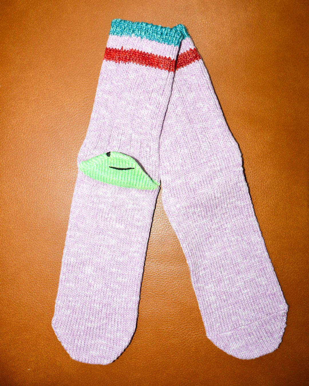 White socks with colorful stripes on a brown surface