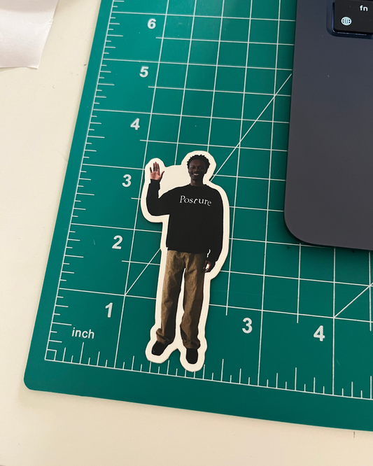 Sticker of a person wearing a Navy blue shirt with text on a green cutting mat.