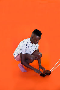 Man crouched down playing a small piano