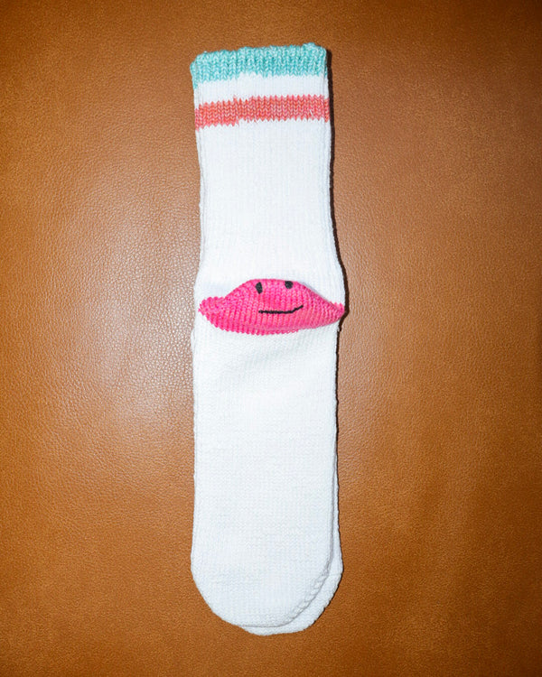 White sock with pink flamingo design on a brown surface