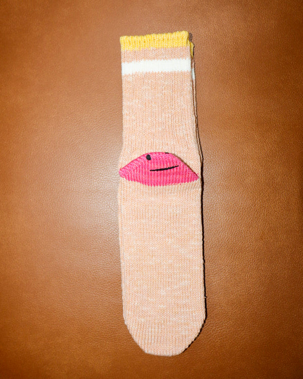 Beige sock with pink lips design on a brown background