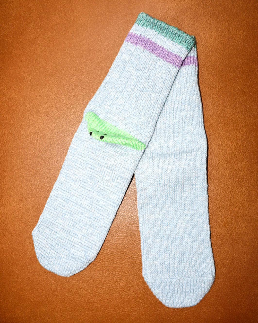 Light green socks with green accents on a brown background