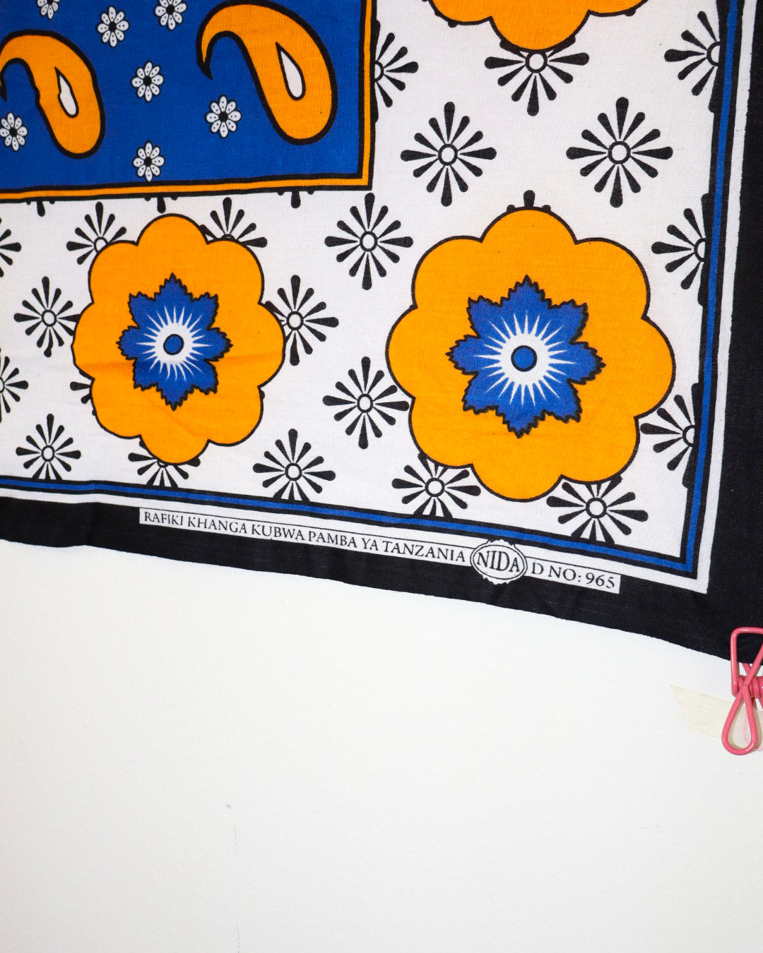 Traditional fabric with orange and blue floral patterns on a white background
