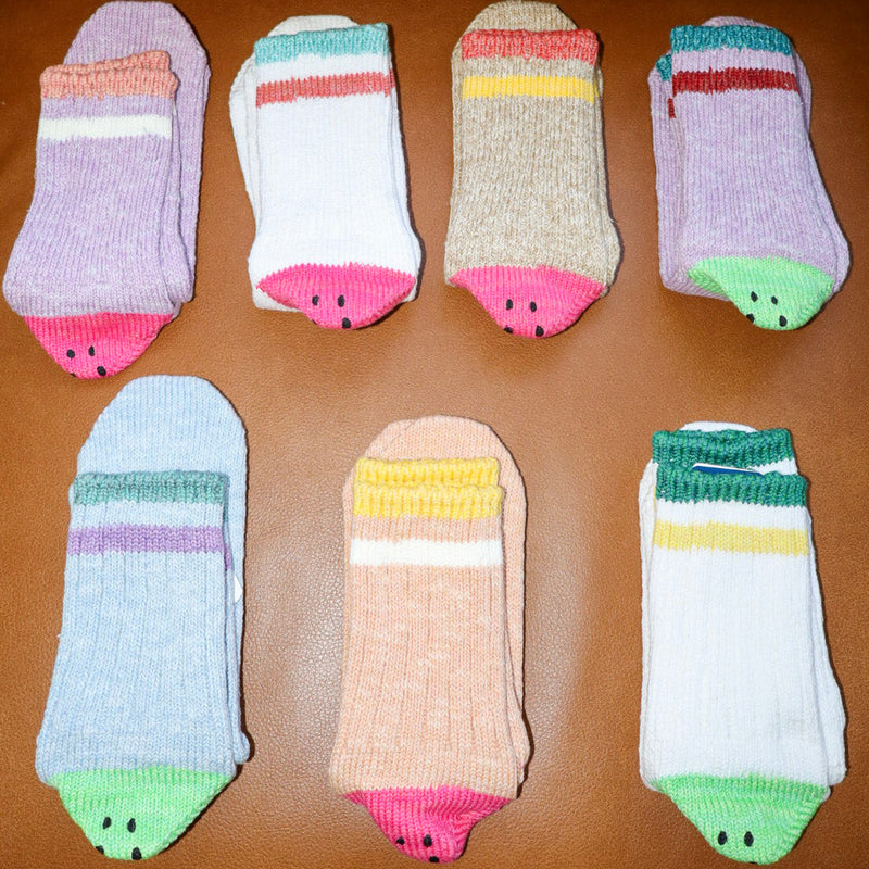 Set of colorful baby socks on a brown surface