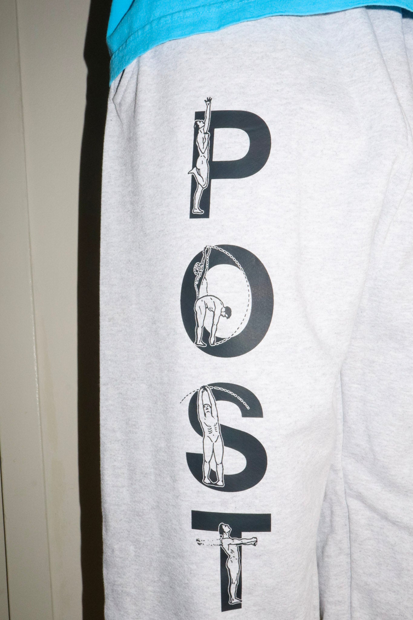 Gray sweatpants with 'POST' graphic design on a plain background