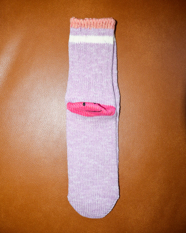 purple sock with pink accents on a brown surface