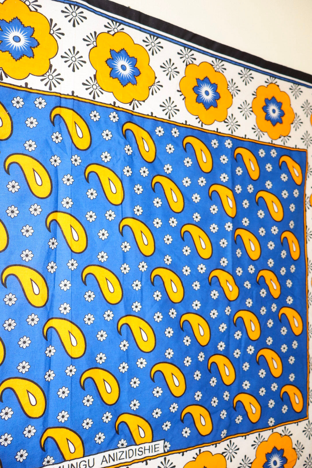 Patterned fabric with yellow paisleys and blue flowers on a blue background