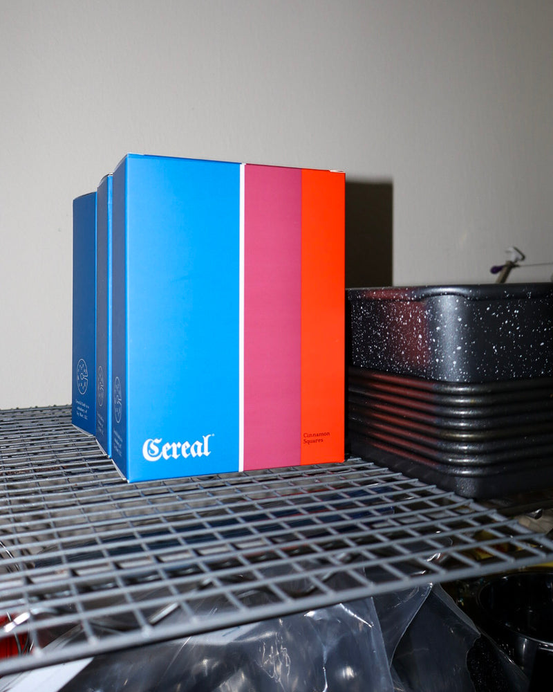 Blue and red cereal box on a metal shelf with a blurred background