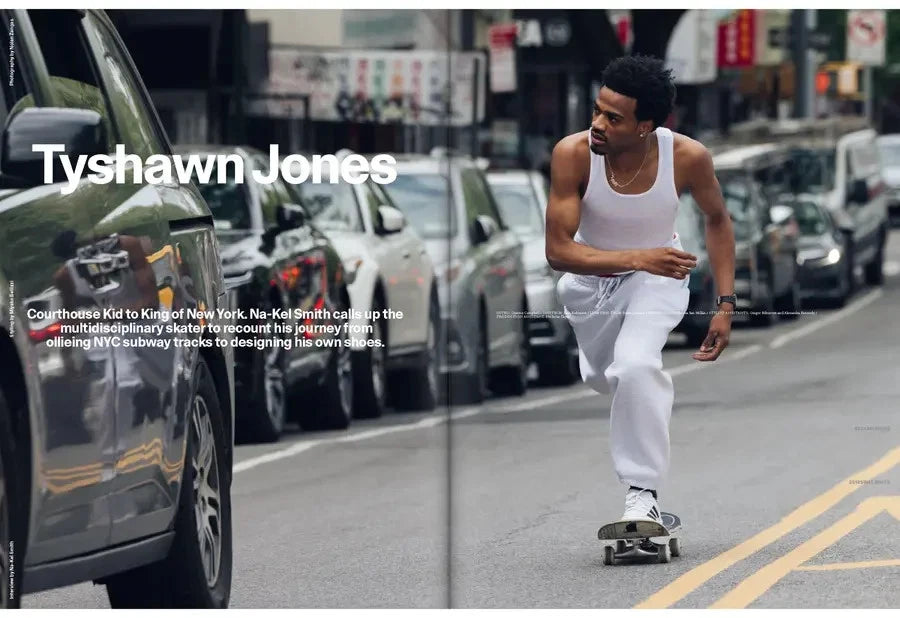 Man skateboarding on a city street with cars and traffic lights in the background