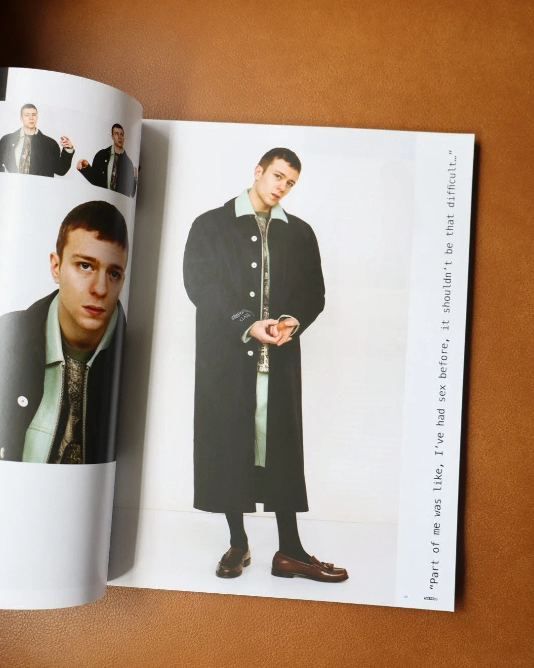 Open magazine showing a model wearing a black coat on a brown background